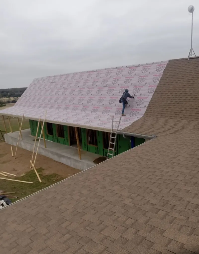 Worker preparing underlayment for a metal roof installation in Palm Bay